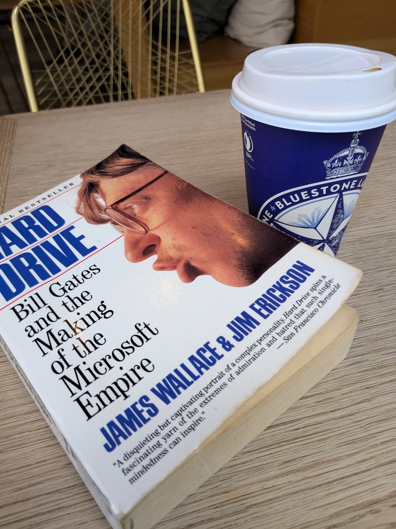 Hard Drive: Bill Gates and the Making of the Microsoft Empire beside a cup of coffee